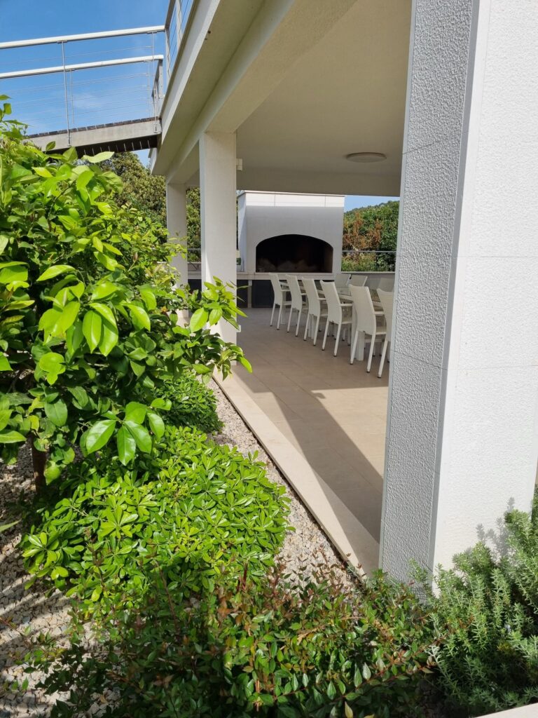 Covered garden terrace and outdoor dining area at Villa ABBA